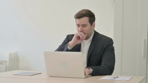 Business Man Coughing While Working On Laptop