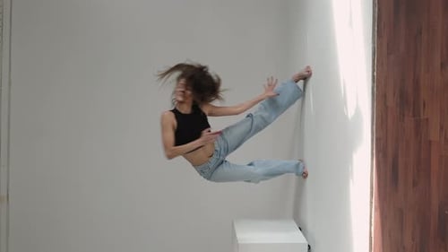 Middleaged Woman Dancing Gracefully in a Minimalist Studio Arms Extended in Fluid Motion Concept