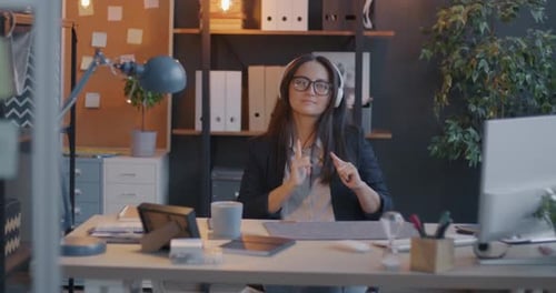 Slow Motion Zoomout of Office Worker Listening to Music Dancing and Singing Relaxing in Workplace in