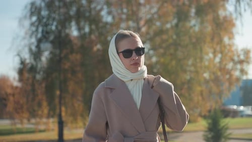 Trendy Female Casually Walking Through Serene Park Environment with Assurance Chic and Confident