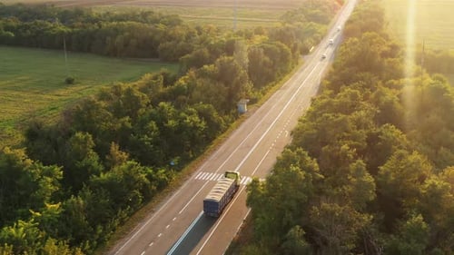 Aerial Shot of a Grain Truck Driving on the Road in Beautiful Countryside in the Summer Sunset Drone