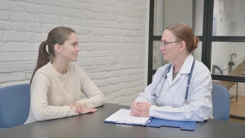 Young Woman Consulting with Doctor in Medical Office