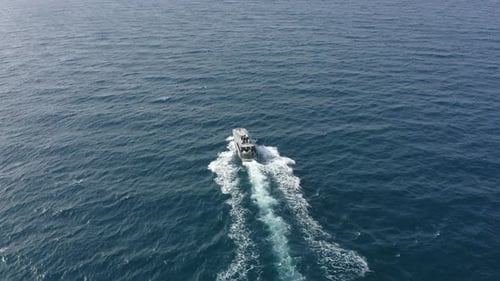 Coastguard vessel patrolling the Sea at high speed, Top down aerial follow footage