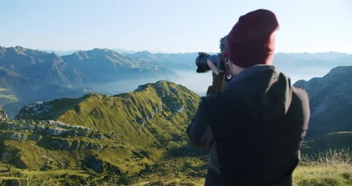 Photographer Capturing Mountain Landscape in Daytime