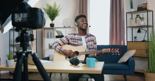 Happy Man Plays Guitar and Sings at Home