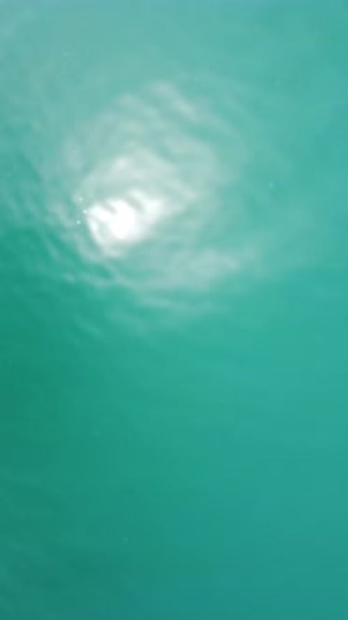 Vertical Aerial View on Sea Water Surface Camera Flies Over Clear Sea Water Sun Glare Abstract