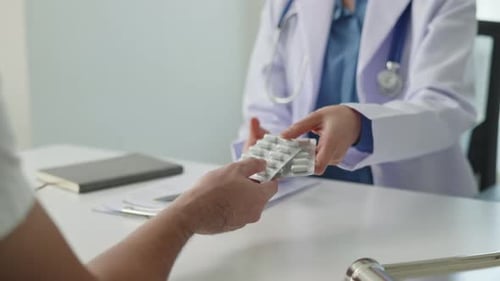 Doctor Giving Patient Pills in Office Clinic