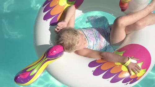 Happy Child Girl nada em um anel inflável em uma piscina ao ar livre