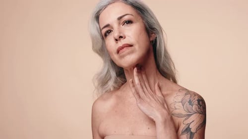 Mature Woman With Gray Hair Touches Her Face