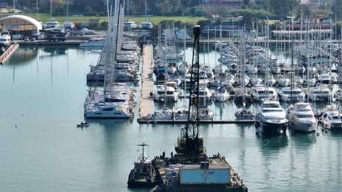 Drohnenaufnahme des Kranschiffs im Jachthafen mit festgemachten Jachten und Segelbooten.