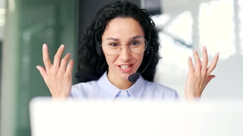 Close up. Confident woman in wireless headset customer service operator talking on video call using