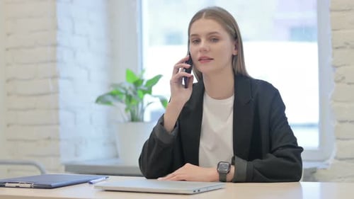 Businesswoman Talking on Phone in Office