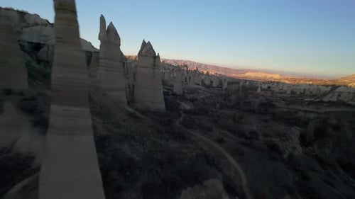 FPV Drone Circling and Flying Between Chimney Like Spires and Phallic Rock Formations in Love Valley