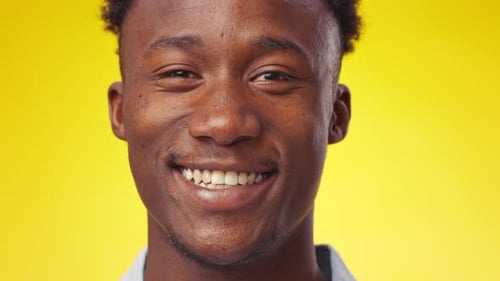 Man Smiling in Front of Yellow Background Close Up