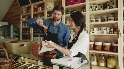 A Young Man and Woman Shop Assistant Working in a Zero-Waste Store