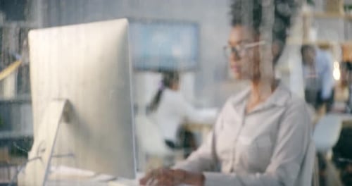 Séquence vidéo 4k d'une femme d'affaires travaillant dans son bureau alors qu'il pleut dehors