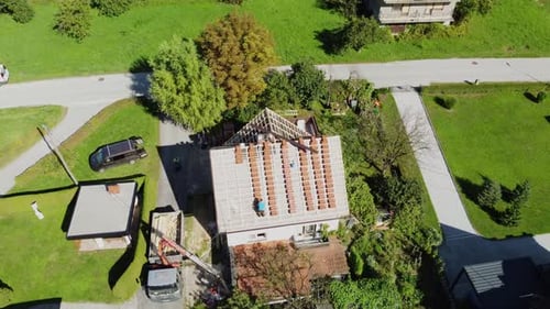 Drone push in tilt down above neat columns of red roofing tiles on house