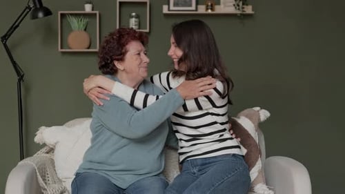 Grandmother and Granddaughter Share Loving Embrace on Couch