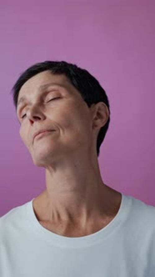 Woman Stretching Neck Muscles on a Pink Background