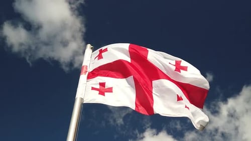 Georgian Flag Waving in Wind Against Blue Sky