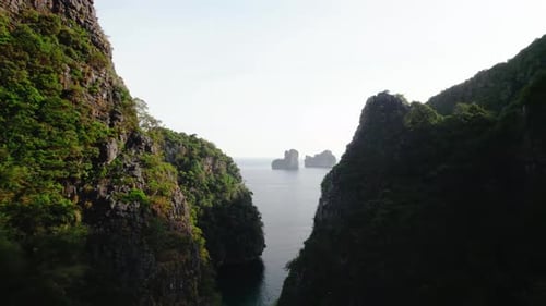 Aerial video passes between cliffs on tropical Maya Bay
