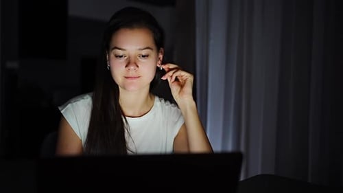 Woman Works at Laptop at Night Indoors