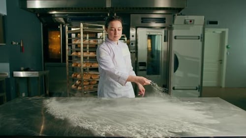 professional chef throws flour on table making flour clouds before preparing bread pastry in bakery