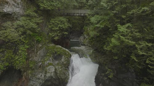 Panning down a suspension bridge and waterfall in Lynn Canyon Vancouver