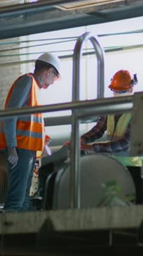 Male Worker Discusses Production and Equipment with Mature Supervisor