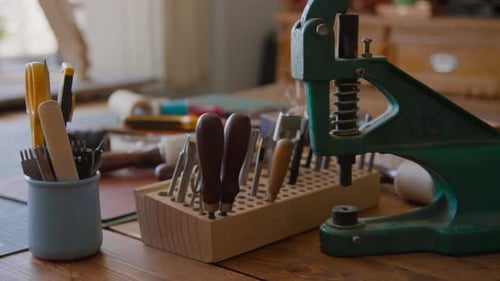 Awls, Punches and Chisels, Green Metal Press on Table in Leather Workshop