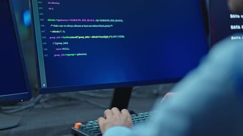 Schulteransicht der Hände des Programmierers auf der Tastatur mit Code