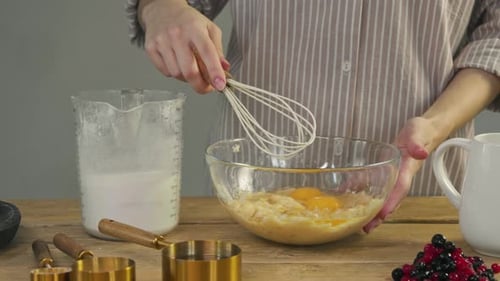 Person mixing batter with eggs and a whisk