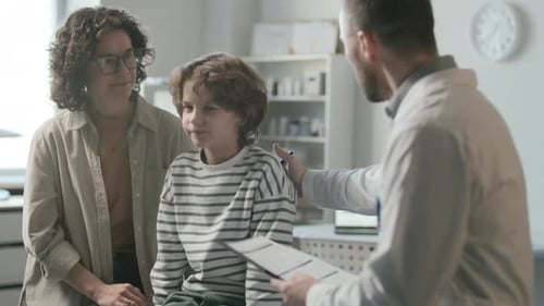Mother and Little Son Getting Medical Consultation from Pediatrician in Clinic