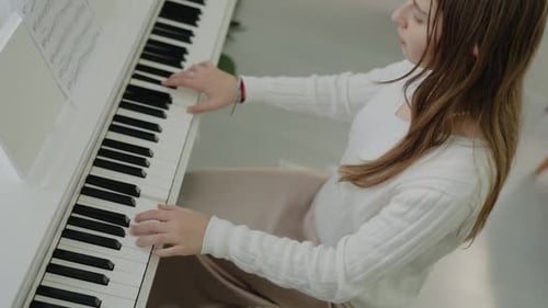 Girl Playing Piano in Bright Room