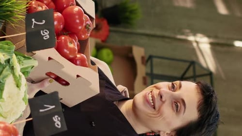Woman holding tomatoes smiles at market