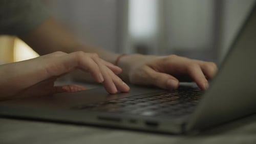 Hands Typing on Laptop Keyboard in Close-Up