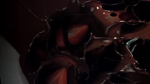Strawberries Splashing into Melted Dark Chocolate Close Up