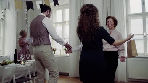 Guests Arriving with Wine at a Birthday Party