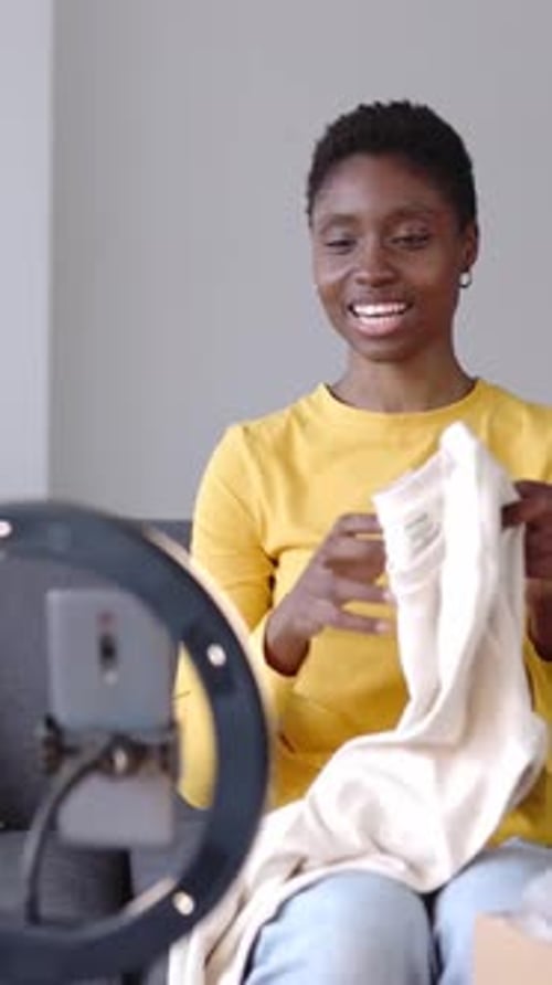 Woman Displays Shirt to Smartphone on Ring Light
