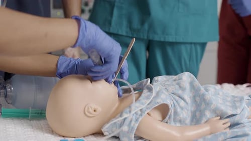 Nurse examines baby dummy in hospital