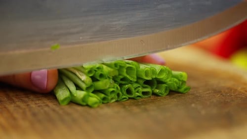 Closeup of Slicing Fresh Green Onions That Jump Out From Under the Knife