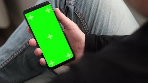 Man Using Smartphone in Vertical Position with Green Mockup Screen Chroma Key