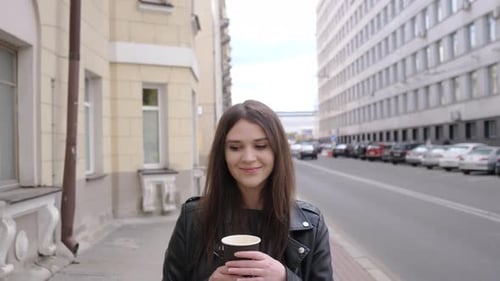 a Beautiful Young Woman Portrait with Coffee Walking Down the Street