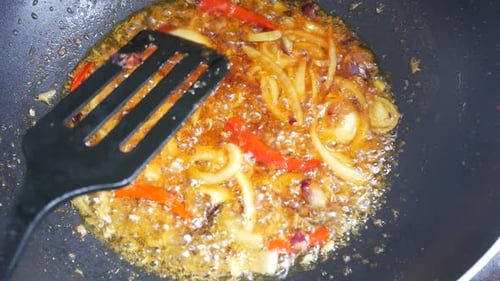 Cooking Onions and Peppers with Sauce in Wok
