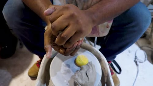 close up view of Africans American black hands molding clay passionately and strongly
