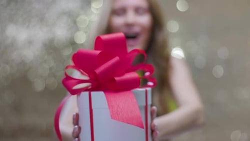 Woman Excitedly Holding Gift Box with Pink Bow