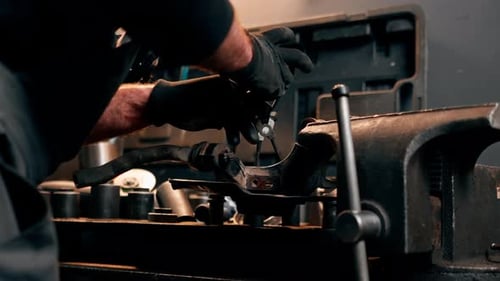 Vertical Video Closeup at a Service Station Car Mechanic at a Machine Repairs with Pliers