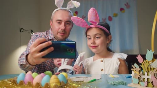 Family Takes a Selfie in Easter House Bunny Costumes at the Table