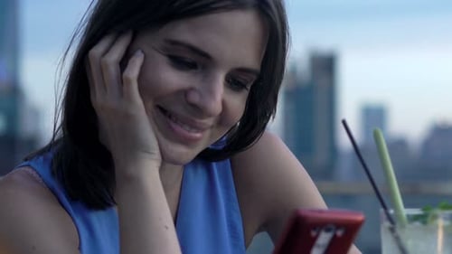 Young Woman Texting at Rooftop Bar