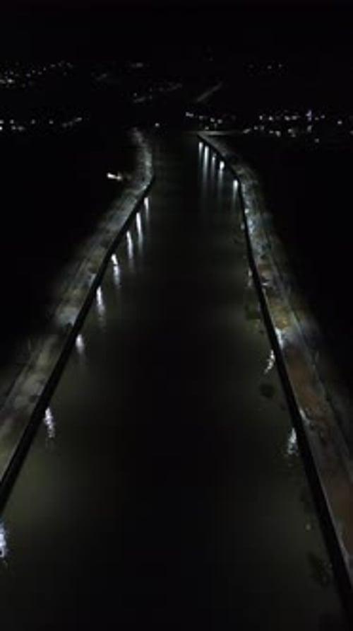 Vertical Drone Footage of Road in the Middle of the River at Night